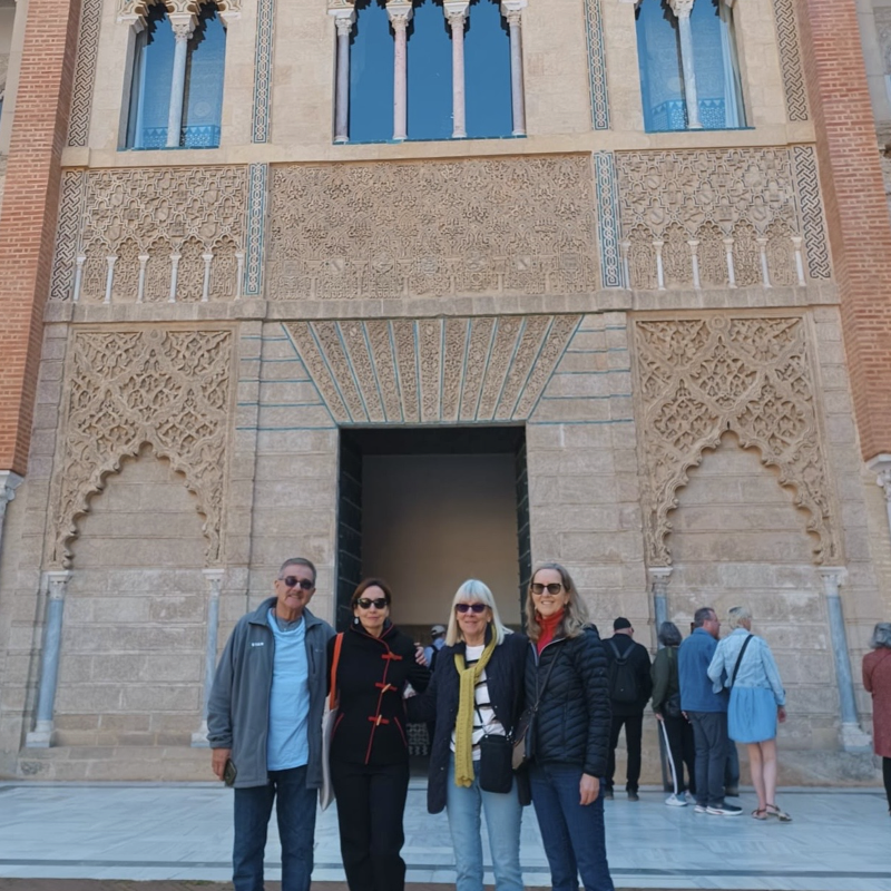A professor and three senior students visiting Seville's royal palace